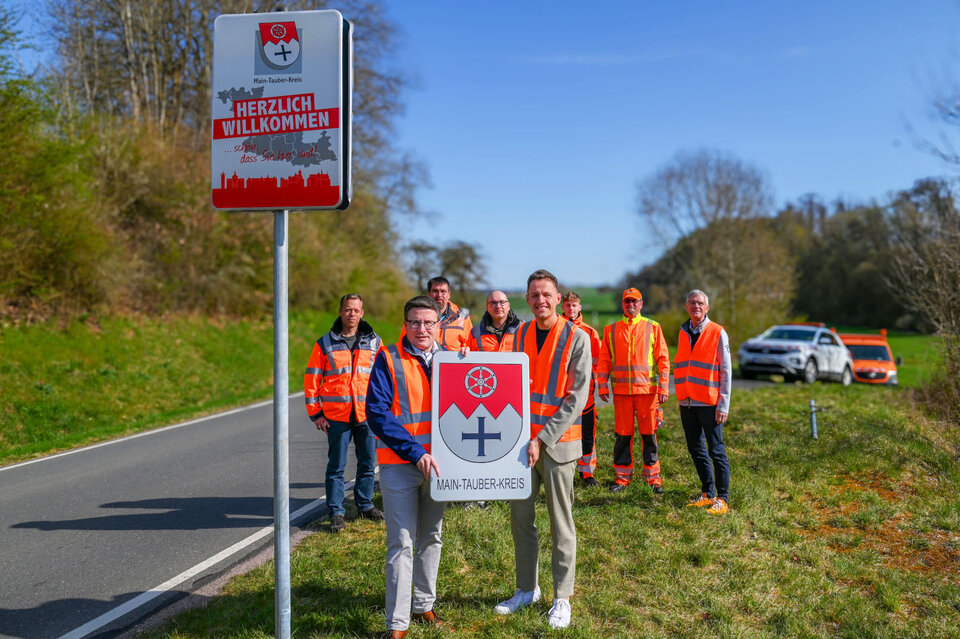 Das neue Schild hängt, das alte wird zum Geschenk: Landrat Christoph Schauder (vorne links) übergab das bisher an der Landkreisgrenze im Einsatz befindliche Schild an Bürgermeister Benjamin Czernin.