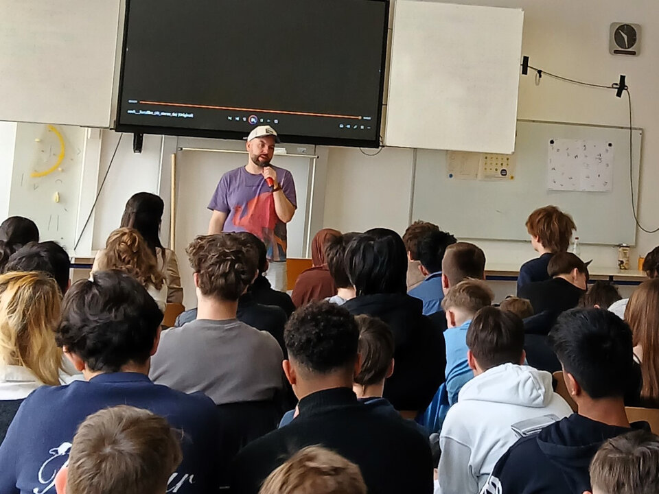 Herr Smekal, Regisseur und Autor des gezeigten Films, im Austausch mit Schülerinnen und Schülern der Klassen 8 des Freihofgymnasiums Göppingen