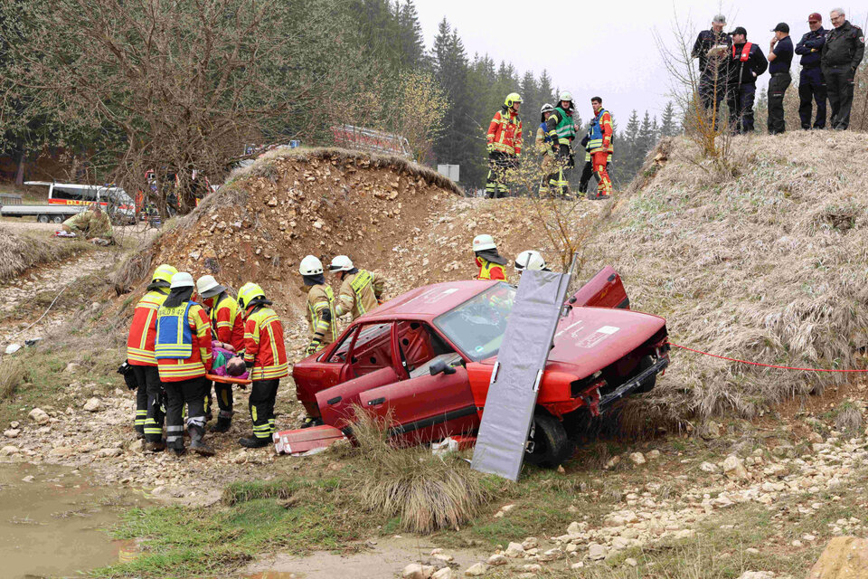 Feuerwehrleute retten eine eingeklemmte Person aus dem Pkw (Station "Badewanne").