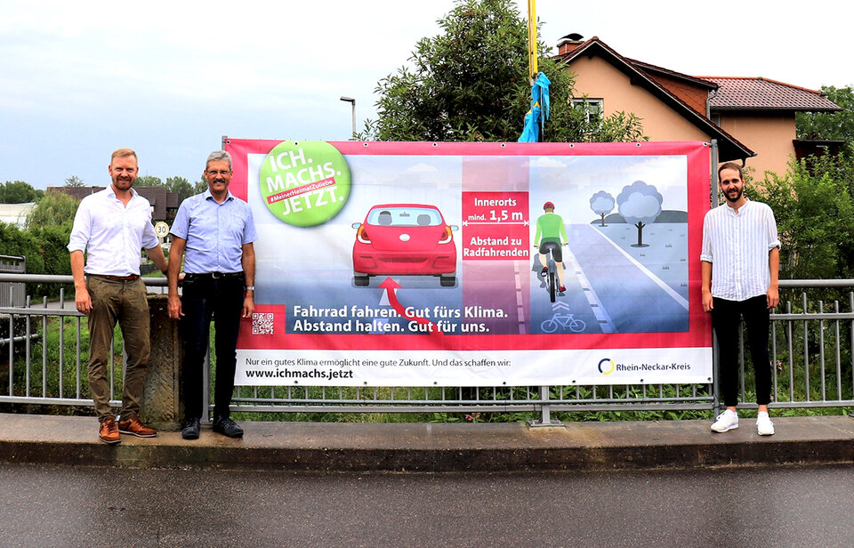 (V.l.n.r.) Dr. Christopher Leo, Dezernent für Mobilität, Umwelt und Technik im Landratsamt, Neidensteins Bürgermeister Frank Gobernatz und Ricardo Beringer von der Stabsstelle Nachhaltige Mobilität des Rhein-Neckar-Kreises präsentierten das großformatige Banner.