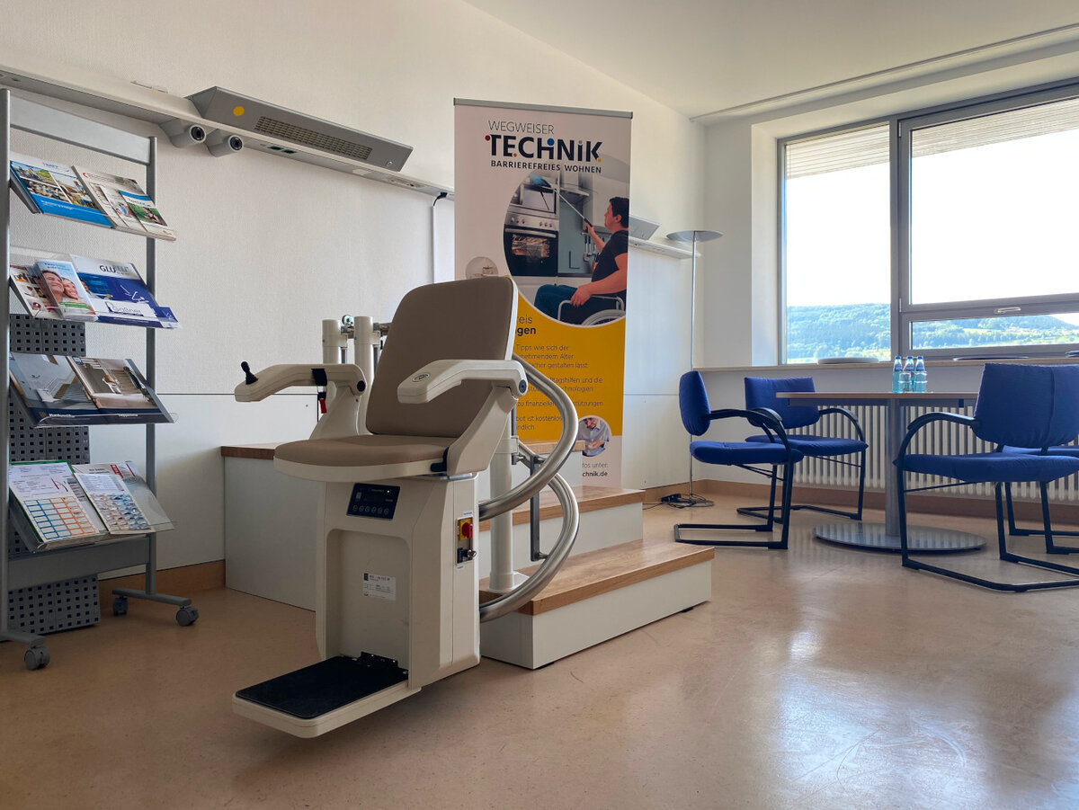 Der Treppenlift fährt über drei Stufen mit einer integrierten Kurve. Direkt in der Ausstellung verortet ist auch eine Sitzgelegenheit für Beratungen, die sowohl von Mitarbeiterinnen der Wohnberatung, als auch des Pflegestützpunktes genutzt werden.