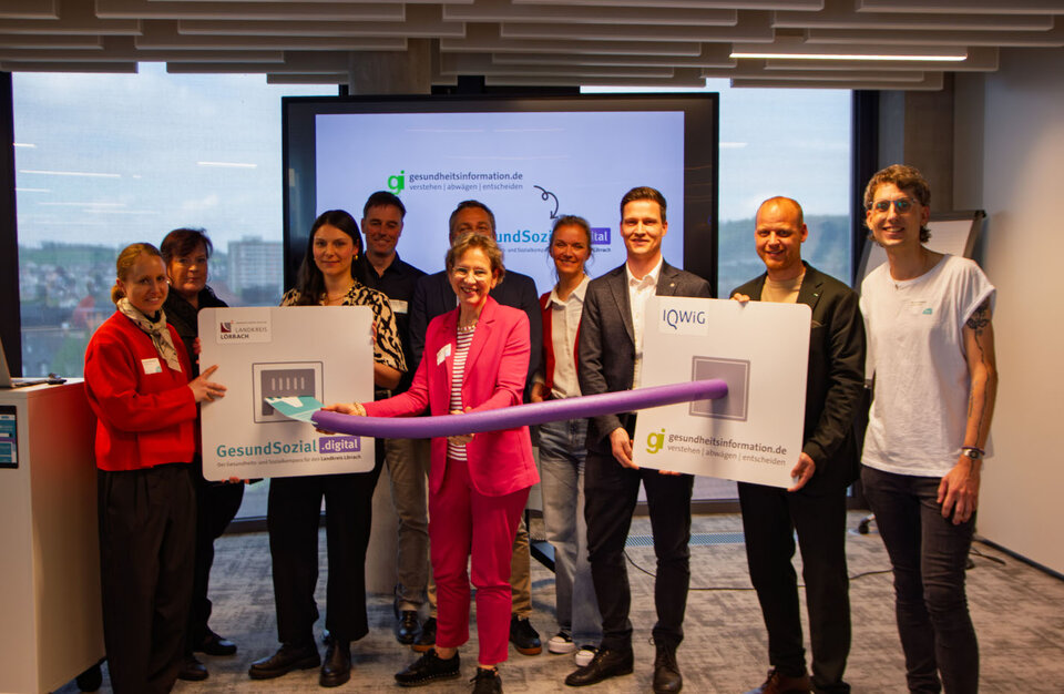 Landrätin Marion Dammann (Mitte) stellt symbolisch die neue Verbindung von gesundheitsinformation.de zum Gesundheits- und Sozialkompass des Landkreises Lörrach „GesundSozial.digital“ her. Freuen sich mit (von links): Cornelia Wülbeck, Elke Zimmermann-Fiscella, Isabell Dörflinger, Alexander Mion, Tilman Rieder, Anne Göhner, Thomas Schlotterbeck (Geschäftsführer der Pocket Rocket GmbH), Carlo Wolf (stellvertretender Geschäftsführer der AOK Hochrhein-Bodensee) und Oli Lou Kramer (Projektleitung Digitaler Gesundheits- und Sozialatlas).
