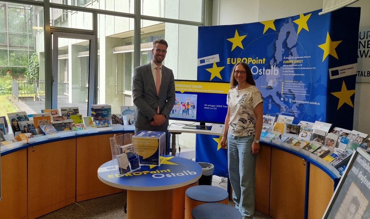 Die Europabeauftragte des Ostalbkreises, Andrea Hahn, begrüßt den geschäftsführenden Leiter der Regionalvertretung der EU-Kommission in München, Dr. Renke Deckarm, im Walk-in-Center des EUROPoint Ostalb im Foyer des Landratsamts in Aalen. Dort und in der Außenstelle des Landratsamts in Schwäbisch Gmünd heißt der vielfältig gestaltete Informationsbereich die Interessierten willkommen